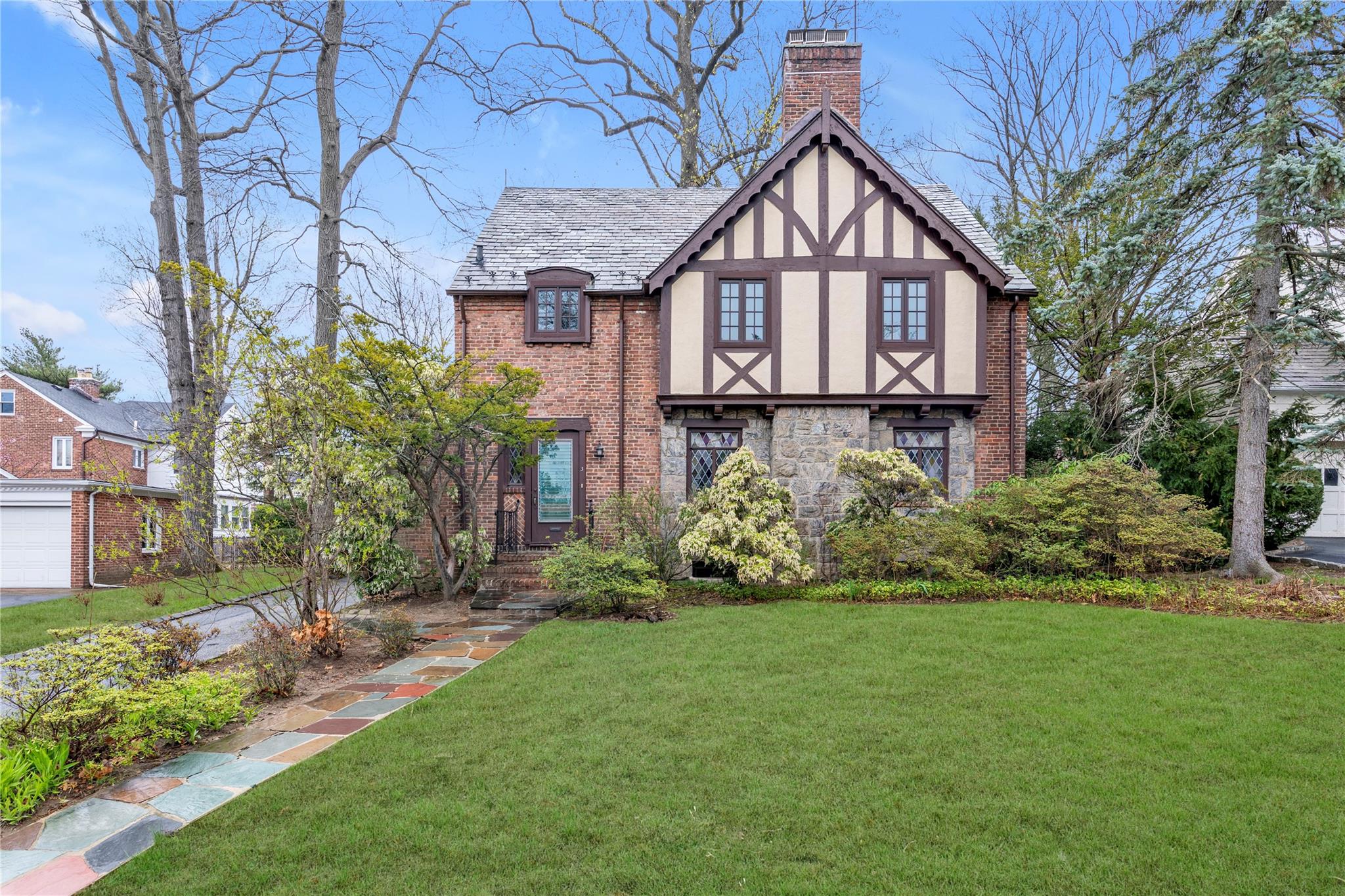 a front view of a house with a yard and garden