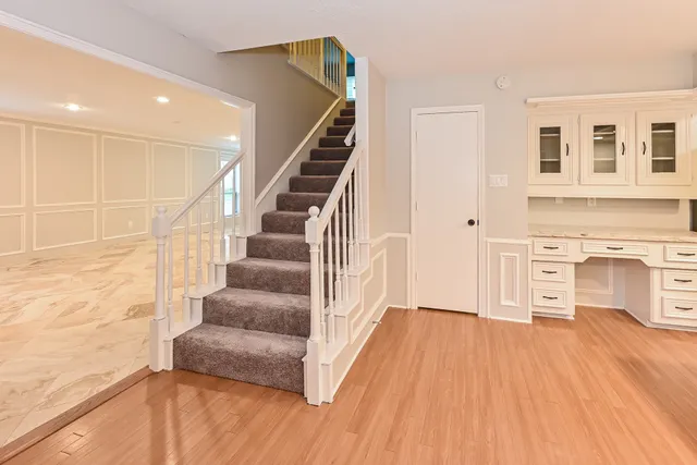 a view of a livingroom with wooden floor and staircase