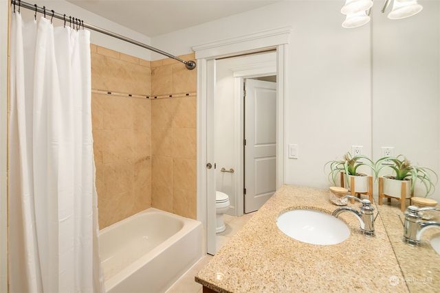 a bathroom with a granite countertop tub sink and mirror