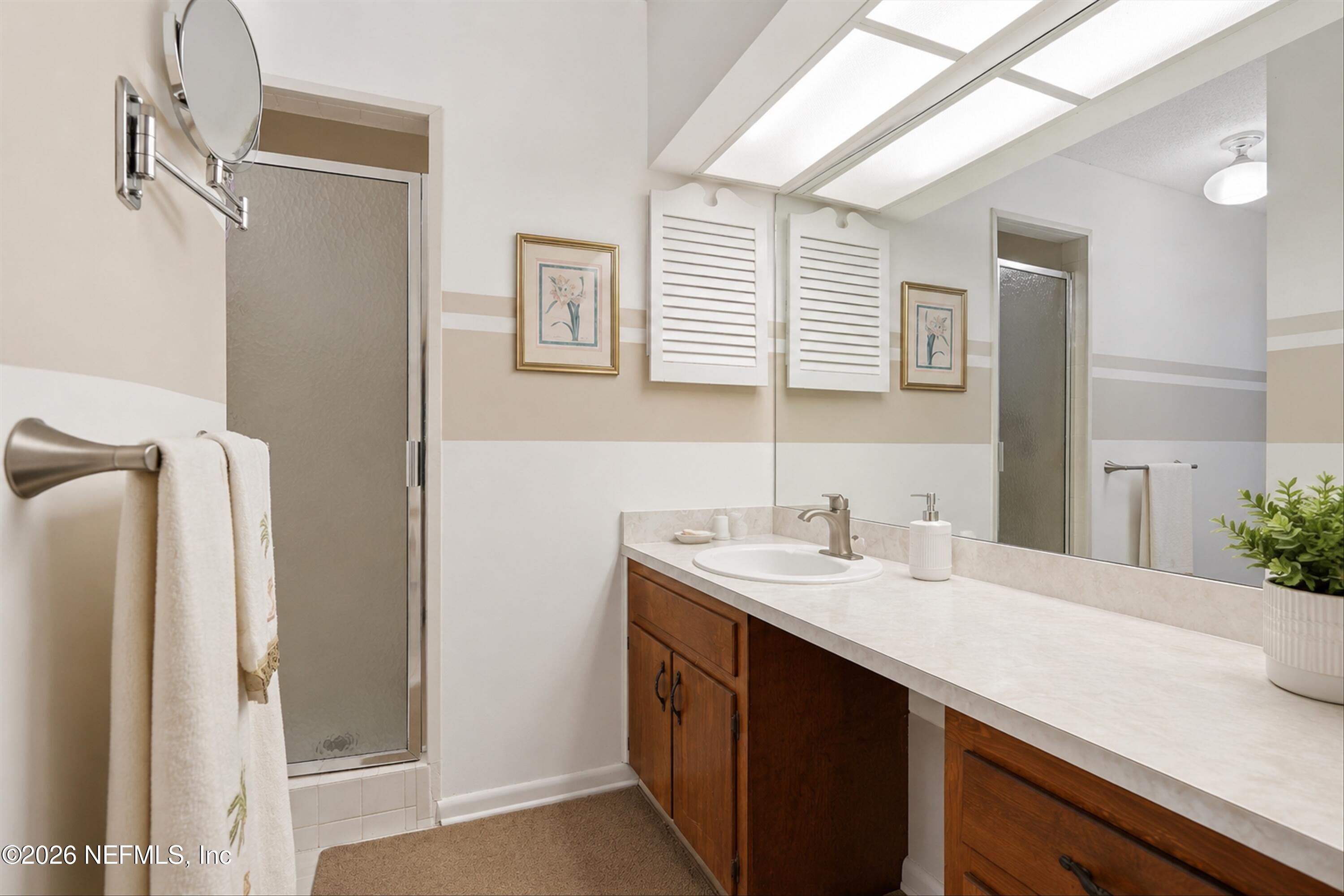 124 Hopkins Street Neptune Beach, FL 32266 - Photo 24 of 44 a bathroom with a sink a mirror and a shower