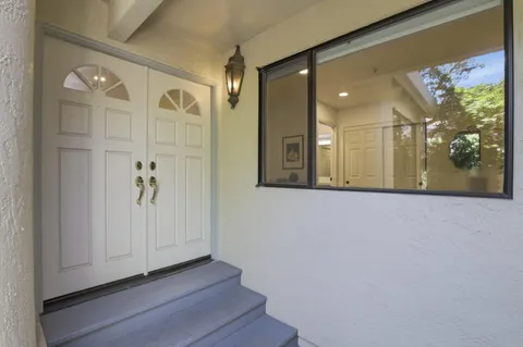 a view of a hallway with wooden floor and a bathroom