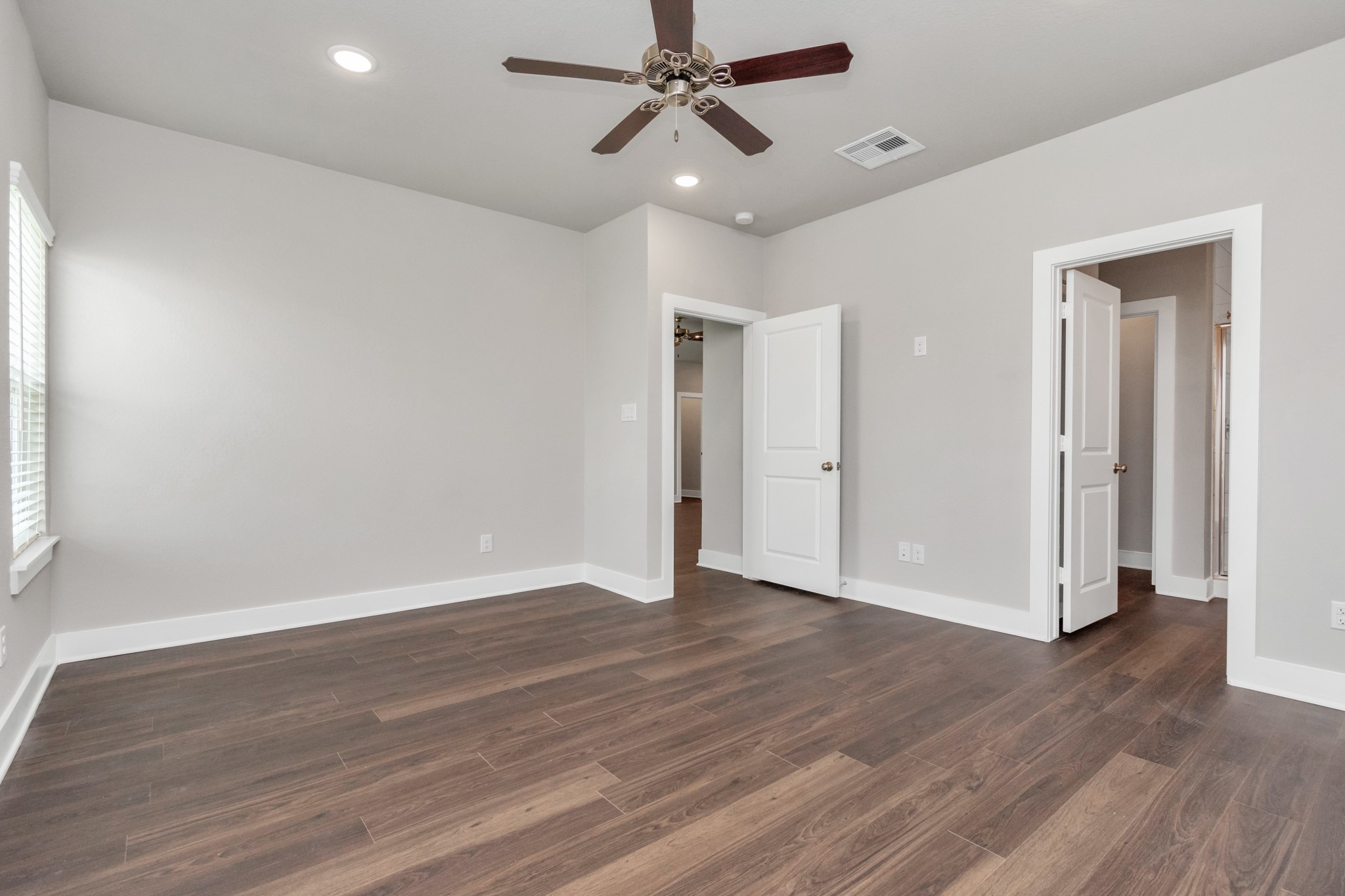 10523 Moon Valley Lane Rosharon, TX 77583 - Photo 8 of 24 an empty room with wooden floor ceiling fan and windows