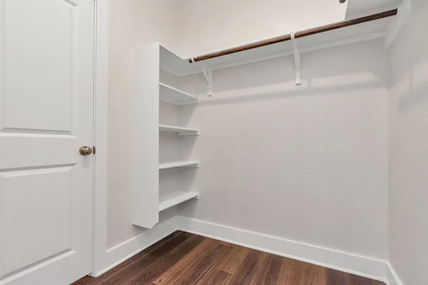 a view of walk in closet with empty racks