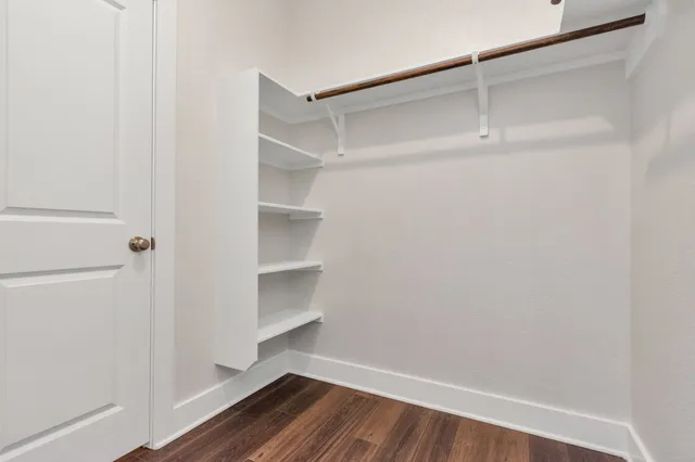 a view of walk in closet with empty racks