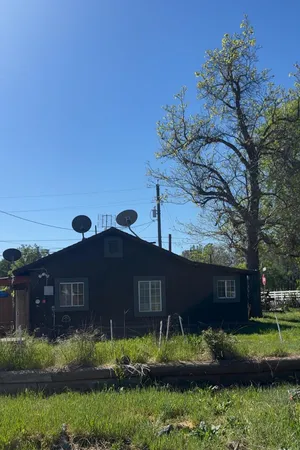 a view of house with garden and tall tress