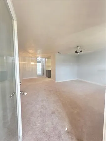 en empty room with windows and fan