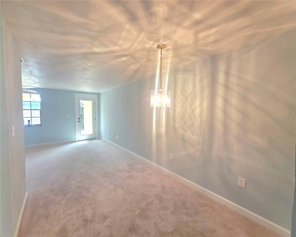 4461 Rustic Drive, Unit 4461 New Port Richey, FL 34652 - Photo 7 of 34 a view of a big room with windows and chandelier fan