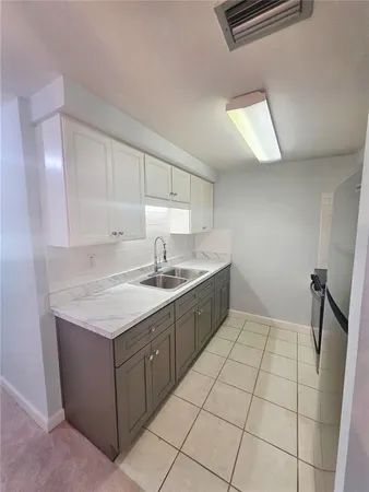 a kitchen with granite countertop a refrigerator and a sink