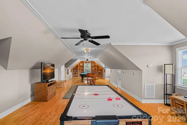 a room with furniture pool table flat screen tv and windows