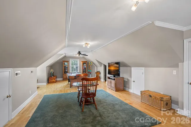 a living room with furniture and a dining table with chairs