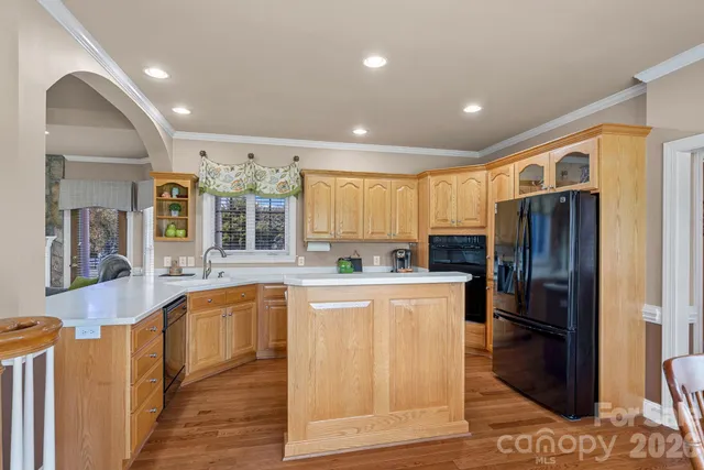 a large kitchen with stainless steel appliances granite countertop a refrigerator and a sink