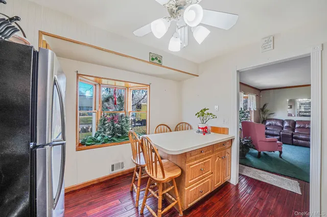 a kitchen with stainless steel appliances a refrigerator a stove a sink dishwasher and white cabinets with wooden floor