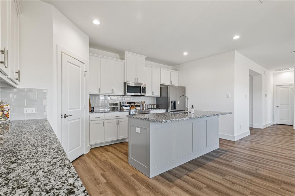 a kitchen with stainless steel appliances a sink and cabinets