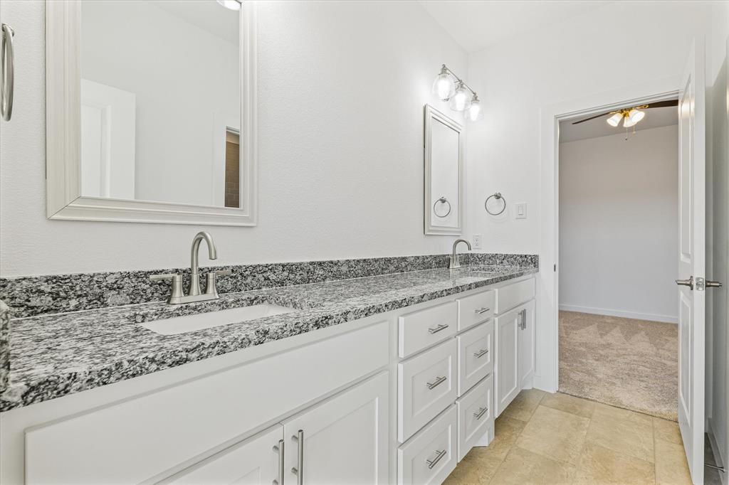 428 Cirrus Circle Muenster, TX 76252 - Photo 18 of 30 a bathroom with a granite countertop sink and a mirror