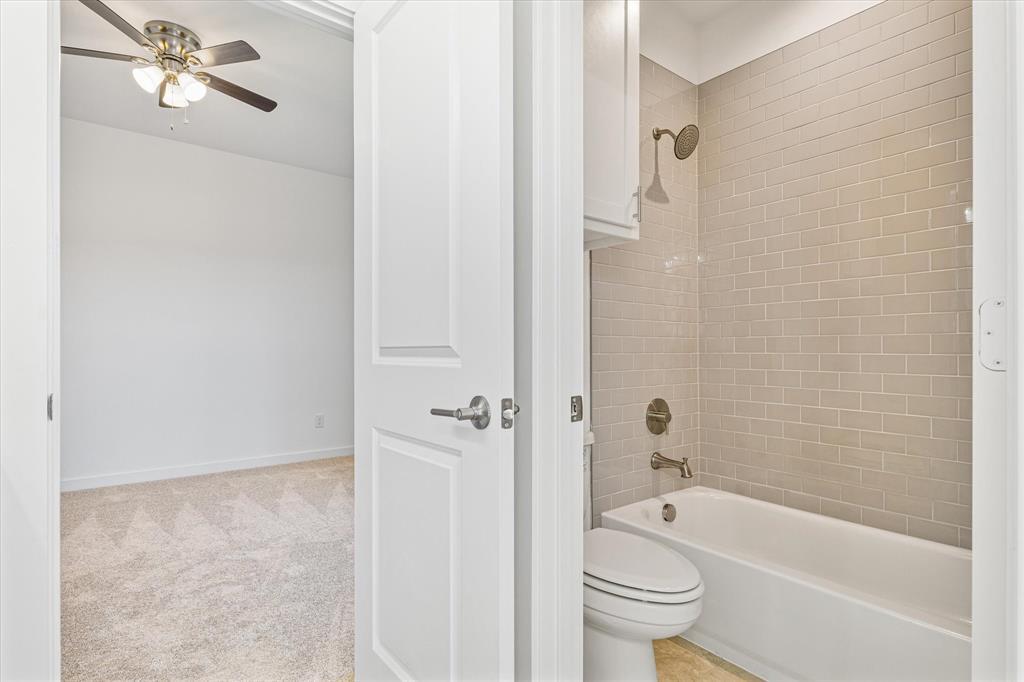 428 Cirrus Circle Muenster, TX 76252 - Photo 19 of 30 a bathroom with a granite countertop toilet a sink and bathtub