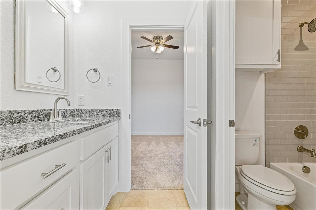 428 Cirrus Circle Muenster, TX 76252 - Photo 20 of 30 a bathroom with a granite countertop sink toilet and shower