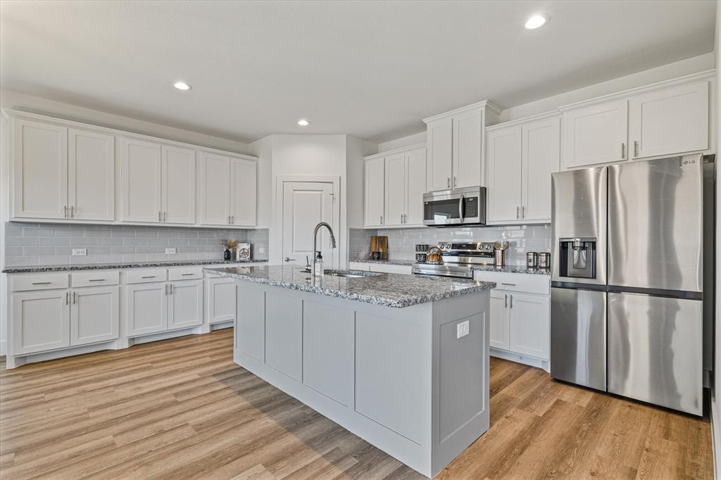 428 Cirrus Circle Muenster, TX 76252 - Photo 5 of 30 a kitchen with stainless steel appliances granite countertop a refrigerator sink and white cabinets