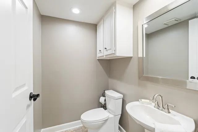 a bathroom with a toilet a sink and mirror