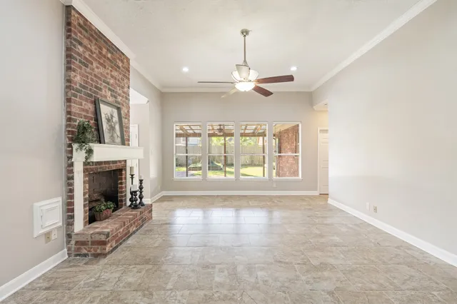 a view of an empty room with a fireplace and a window