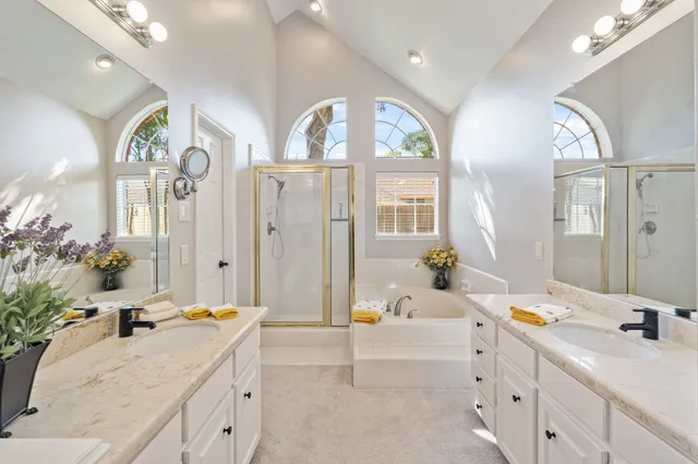 a spacious bathroom with a tub sink and mirror