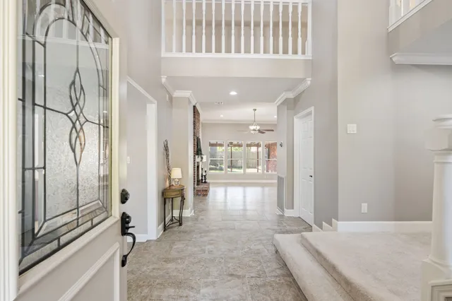 a view of a hallway with wooden floor and chandelier