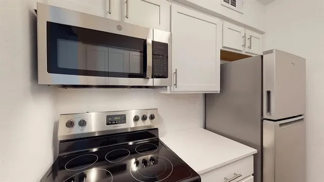a kitchen with stainless steel appliances a stove a microwave and a refrigerator