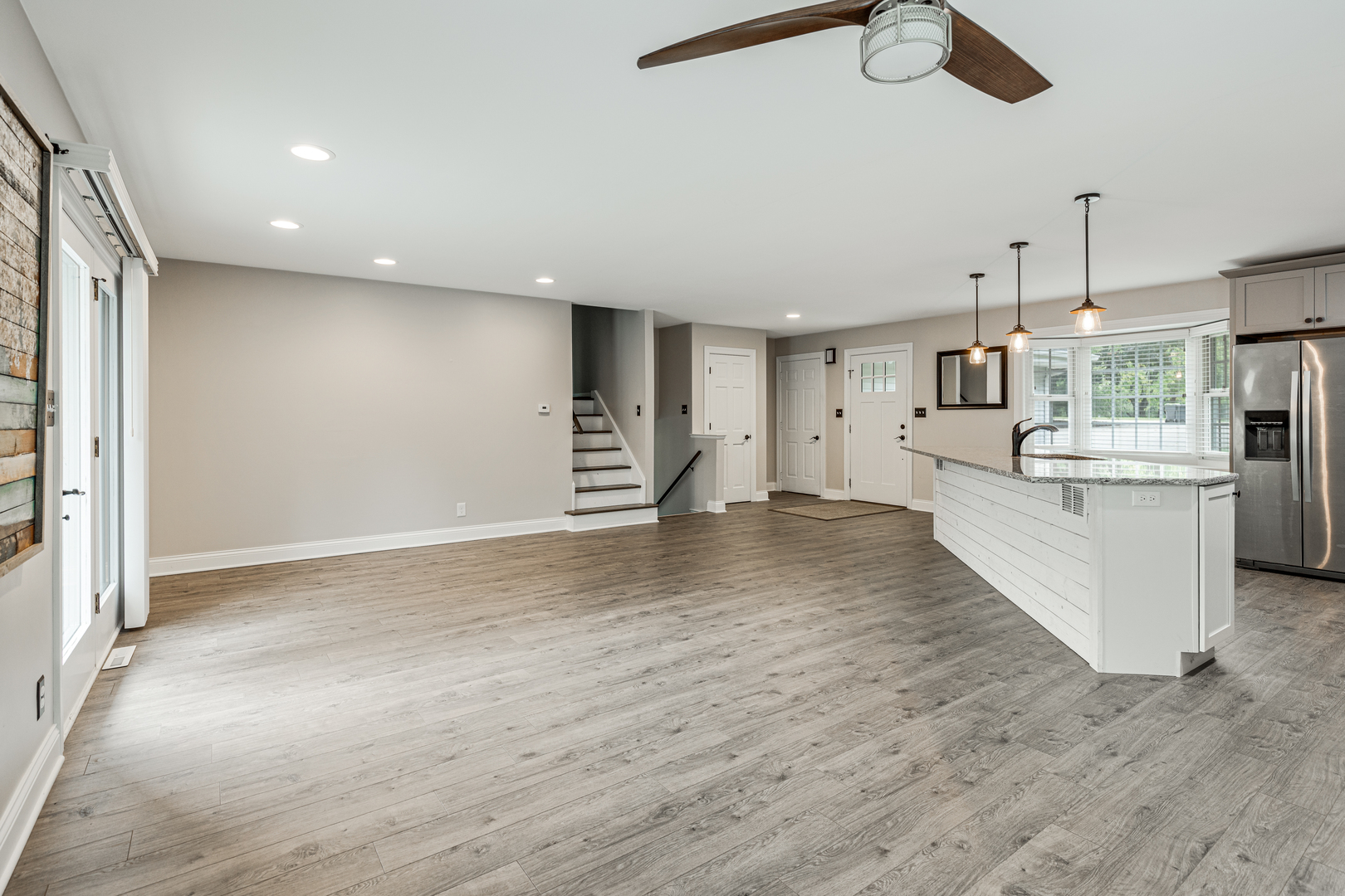 1N136 Pouley Road Elburn, IL 60119 - Photo 7 of 30 an empty room with wooden floor kitchen view and windows