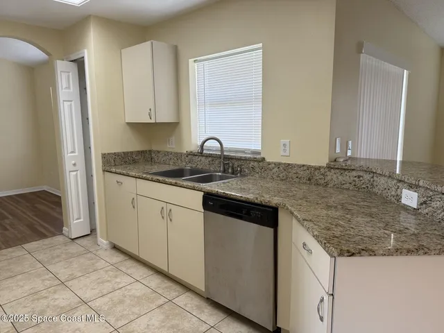 a kitchen with granite countertop a sink and a stove