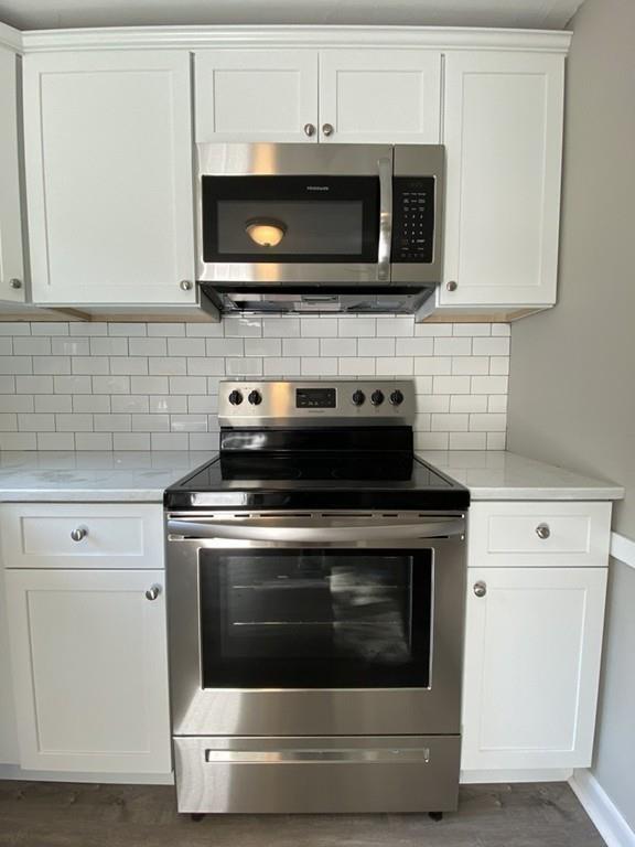 70 Plumtree Circle Springfield, MA 01118 - Photo 8 of 29 a stove top oven sitting inside of a kitchen and white cabinets