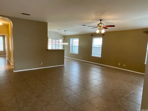 an empty room with windows and fan