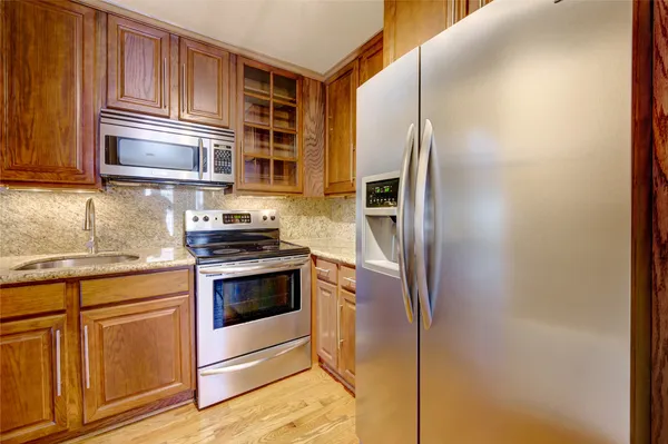 a kitchen with stainless steel appliances granite countertop a stove and a refrigerator