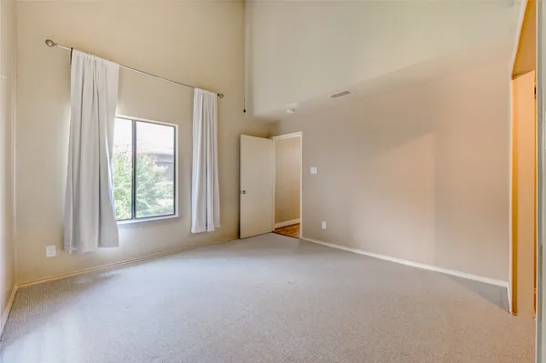a view of a big room with windows and chandelier fan