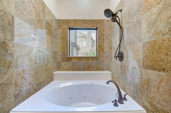 a white bath tub sitting next to a white sink and vanity