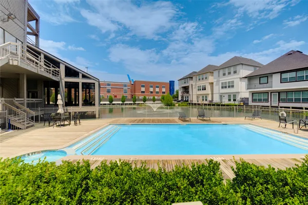 a swimming pool view with a seating space and a garden view