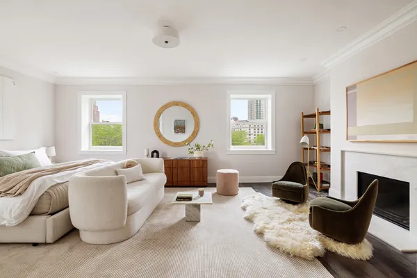 a living room with furniture a fireplace and a large window