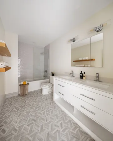 a bathroom with a double vanity sink toilet and a mirror