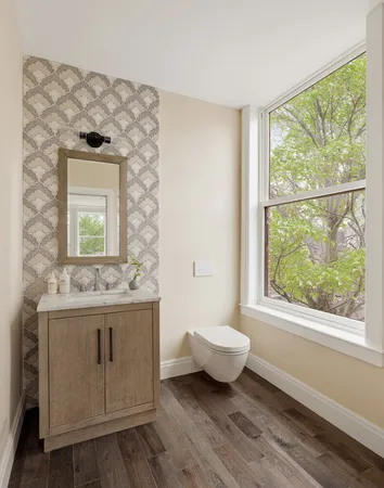 a bathroom with a granite countertop sink a toilet and a window