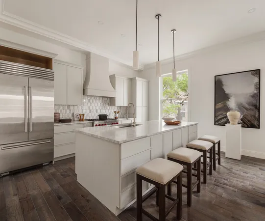 a kitchen with stainless steel appliances granite countertop a stove a refrigerator a microwave a dining table and chairs with wooden floor