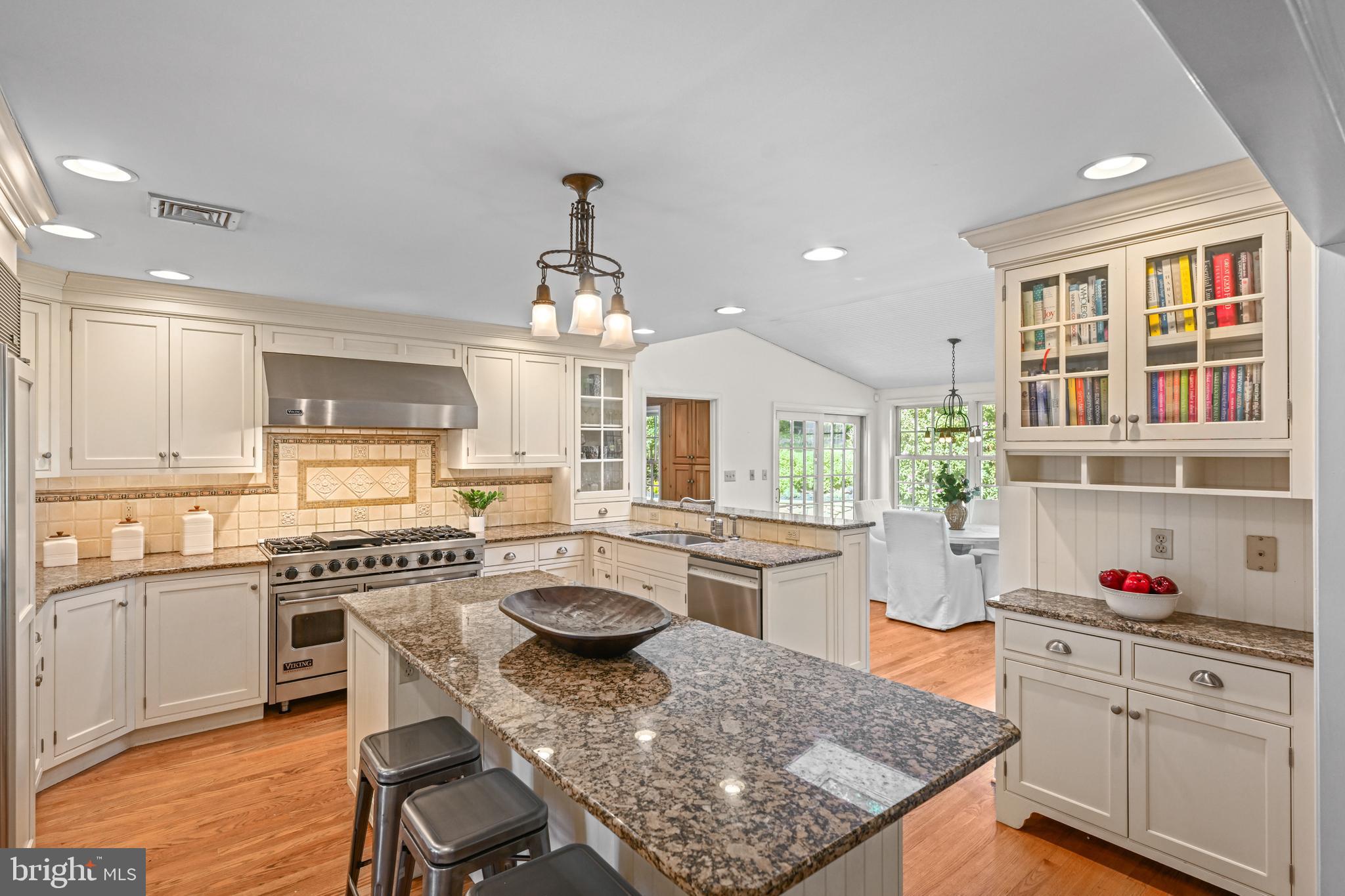 977 Ivycroft Road Wayne, PA 19087 - Photo 8 of 38 a kitchen with a stove a kitchen island white cabinets and wooden floor