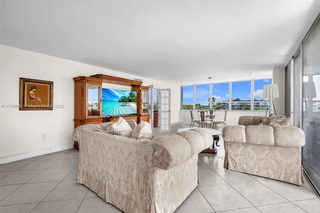 a living room with furniture and a view of kitchen