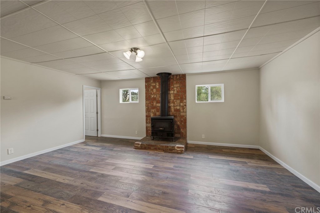 6436 Old Highway 53 Clearlake, CA 95422 - Photo 12 of 27 an empty room with wooden floor and windows