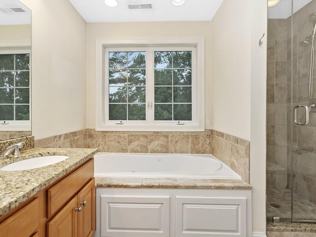 179 Florence Road Waltham, MA 02453 - Photo 23 of 37 a bathroom with a granite countertop tub sink and mirror