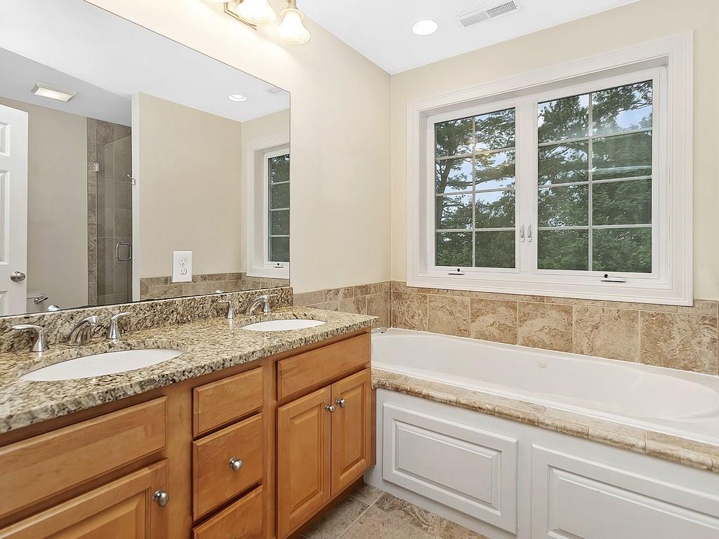 179 Florence Road Waltham, MA 02453 - Photo 24 of 37 a bathroom with a granite countertop sink mirror and a bathtub next to a window