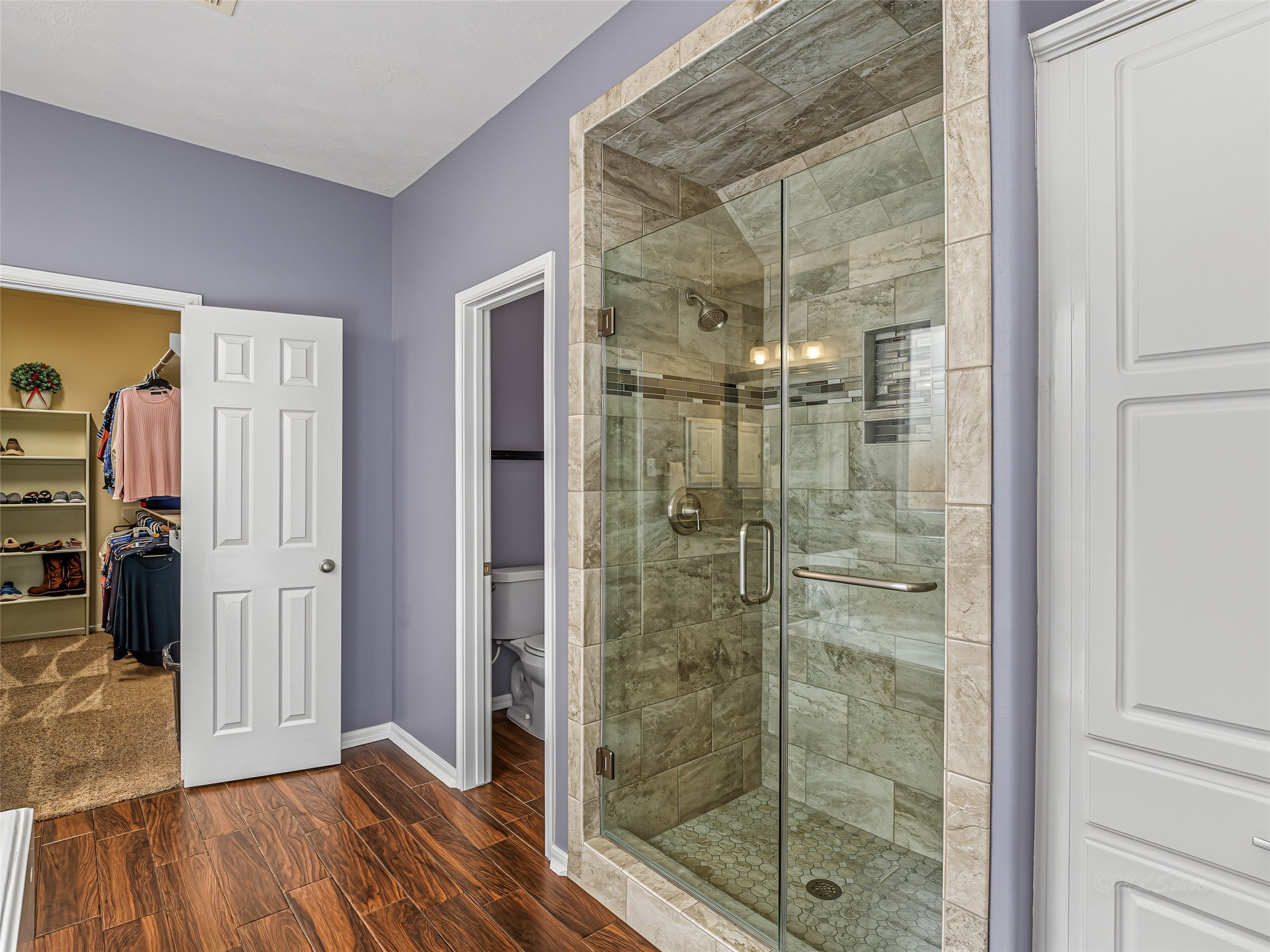 2210 Fox Path Katy, TX 77494 - Photo 28 of 47 To the right sits a contemporary walk-in shower framed with timeless stone-look tile and an elegant mosaic accent band, complete with a heavy, seamless glass door.