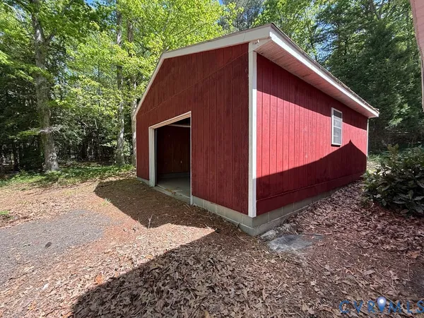 a wooden house with a yard and large trees