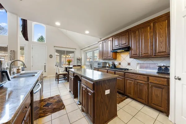 a kitchen with granite countertop a sink stove and cabinets