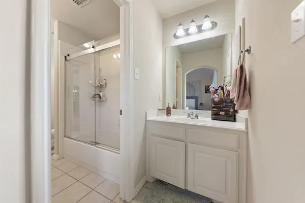 a bathroom with a double vanity sink mirror and shower
