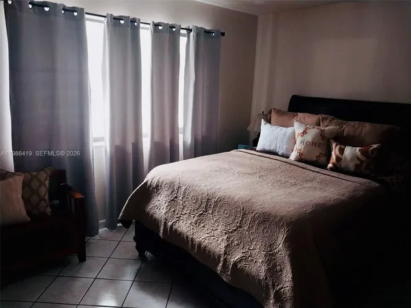 a bed sitting in a bedroom next to a window and a shower