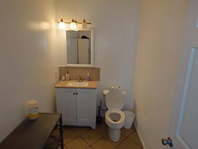 a bathroom with a toilet sink and mirror