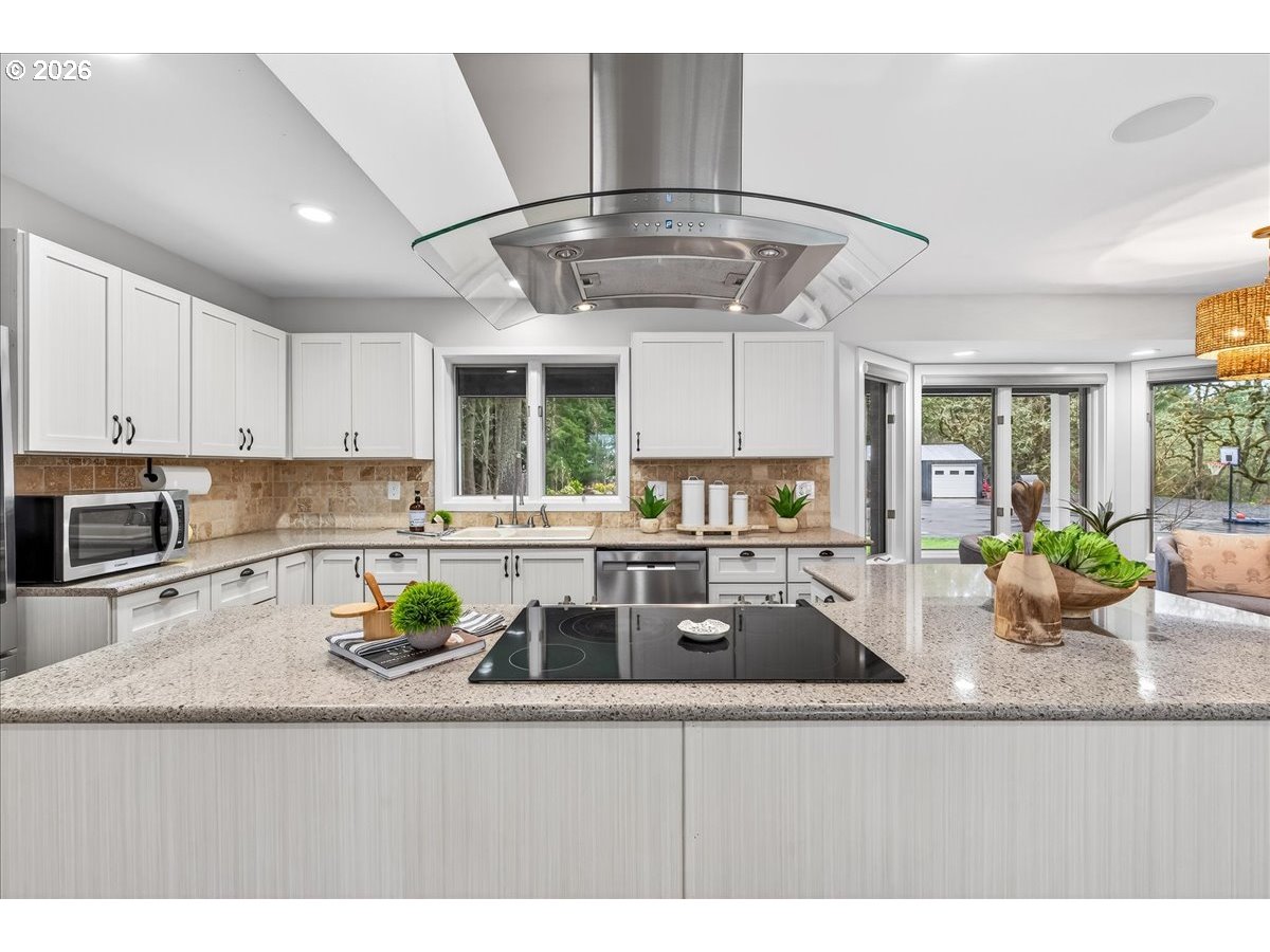 29009 Southwest Burkhalter Road Hillsboro, OR 97123 - Photo 13 of 48 a kitchen with stainless steel appliances granite countertop a sink a stove top oven a counter space and cabinets